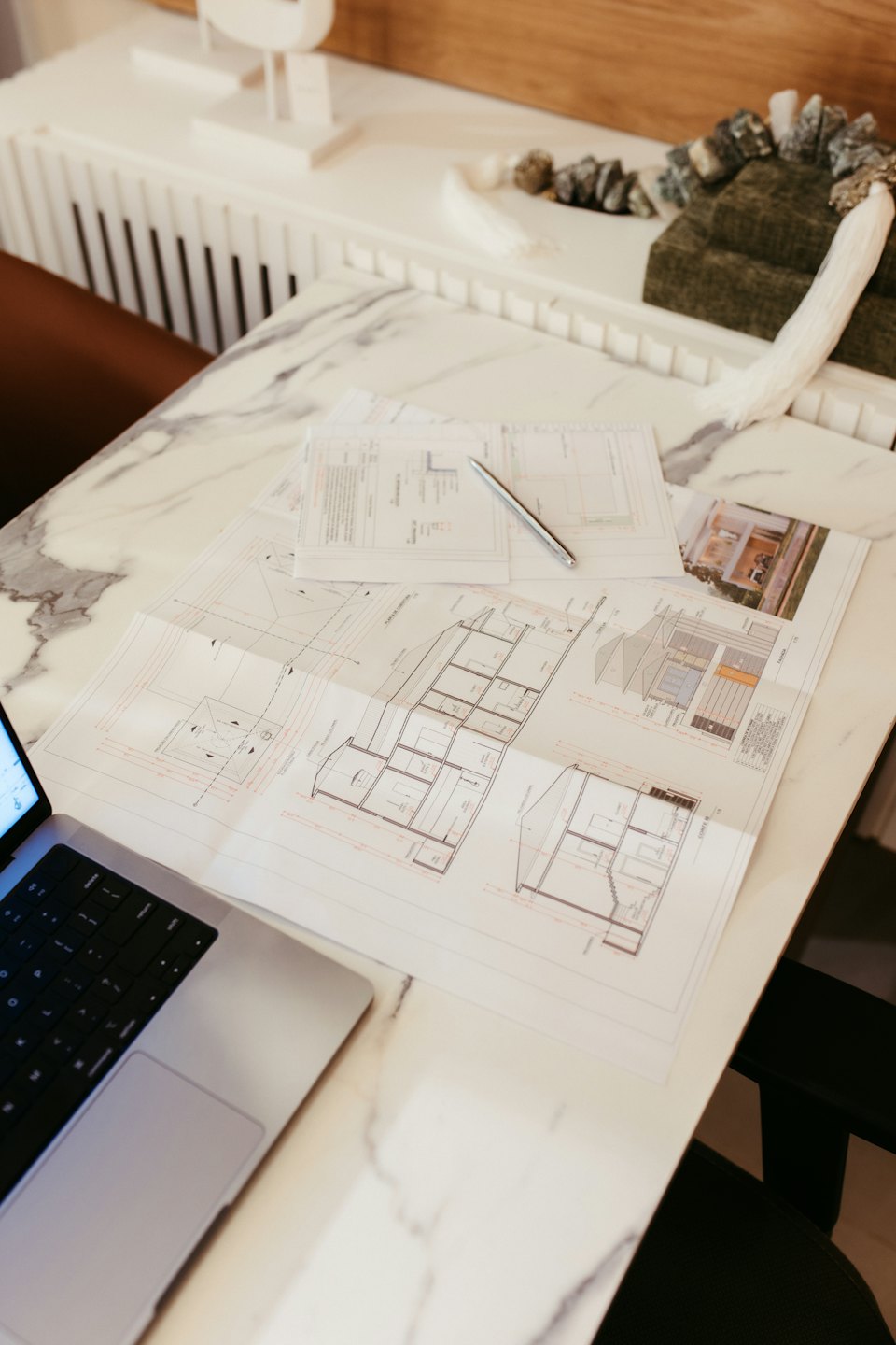 Servizi Progetti architettonici e computer portatile su un tavolo di marmo.
